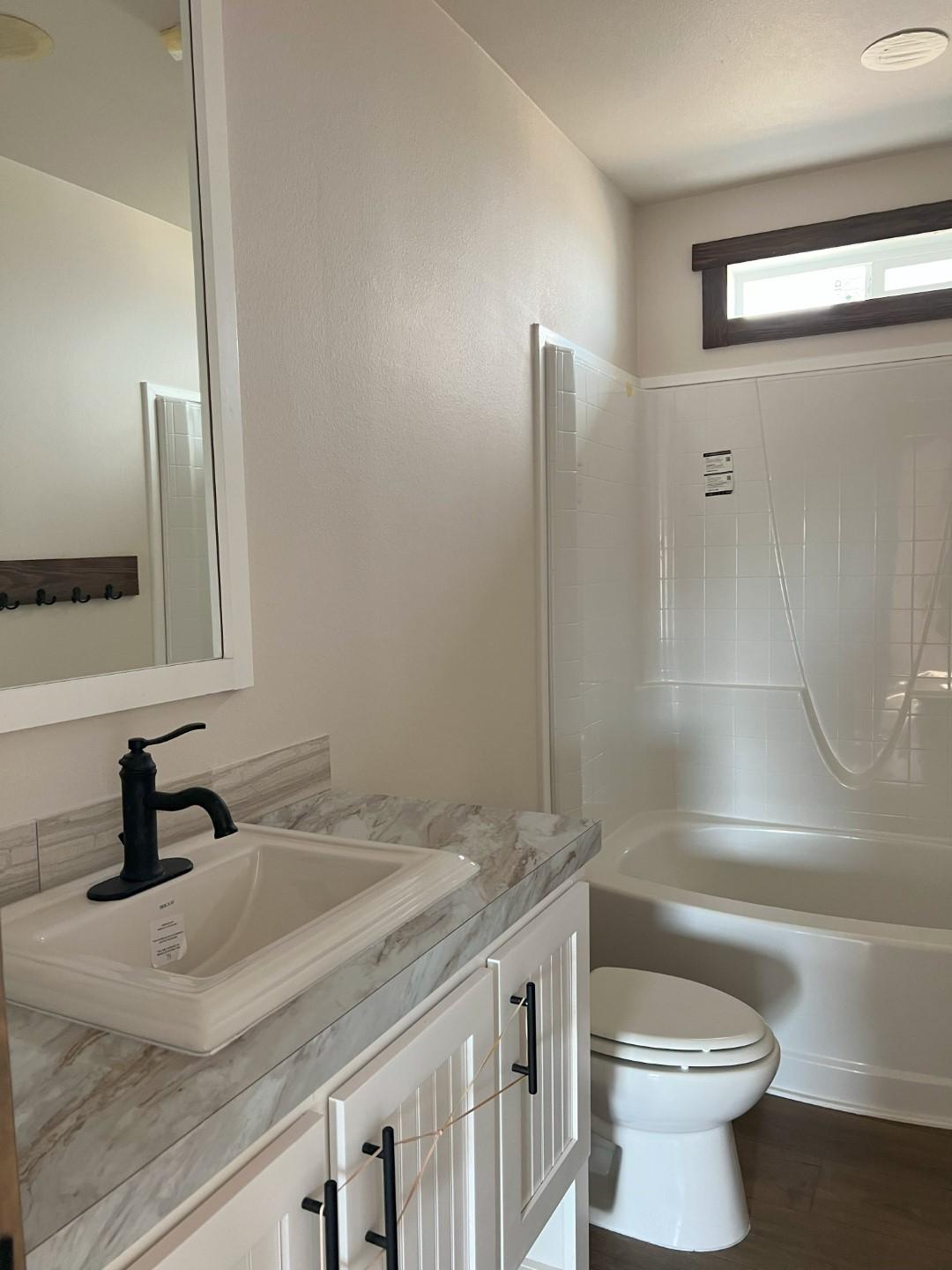 Guest bathroom with oval tub and farmhouse faucet in The Clover by Fleetwood Homes